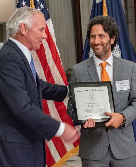 Gov. Henry McMaster, left, presents the 2021 Governor's Young Scientist Award for Excellence in Scientific Research to Marco Ajello. (Photo/Provided)