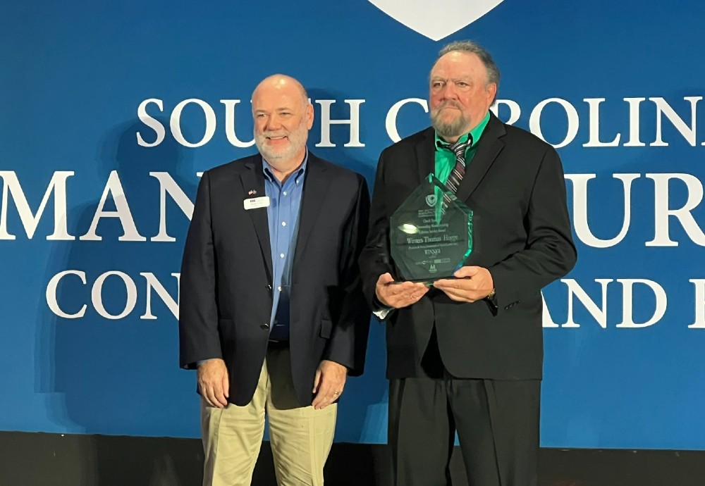 SCMEP President and CEO Andy Carr, left, presents Thomas Hogge with the Chuck Spangler Outstanding Manufacturing  Lifetime Service Award. (Photo/Ross Norton)