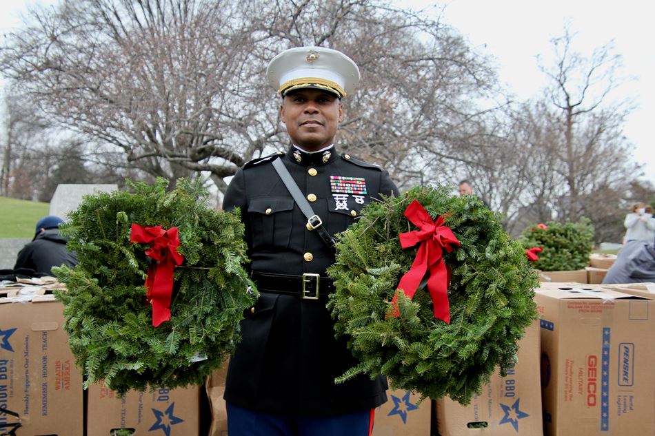 A Marine officer carries wreaths, two of the 250,000 distributed at Arlington Cemetery, to the graves of fallen veterans on Dec. 18. (Photo/Provided)