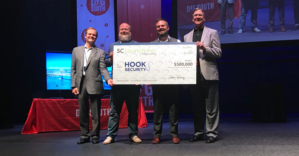 Lee Macilwinen, SCRA investment manager; Adam Anderson, Hook Security cofounder and chairman of the board; Zachary Eikenberry, Hook Security cofounder and CEO and Bob Quinn, SCRA executive director pose with the latest SCRA investment. (Photo/Provided)