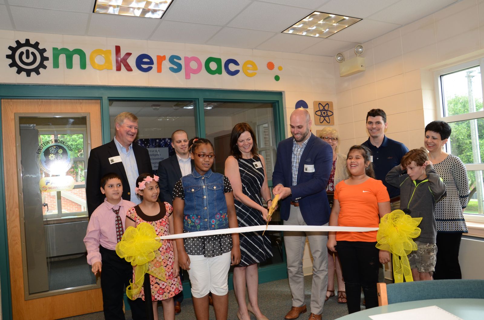 Participating in a ribbon cutting of Einstein's Workshop are, from left, student Azael Cruz, Grant Burns with AFL, student Cailynn-Ann Campos, Josh Sigman with AFL, student Akeylah Howard, Corie Culp with AFL, Joel Douglass with ScanSource, Joan Burkett with ScanSource, student Heilyin Sanchez, Jason Motte with ScanSource, student Cameron Stiff and Jill Kremer with ScanSource. (Photo/Provided)
