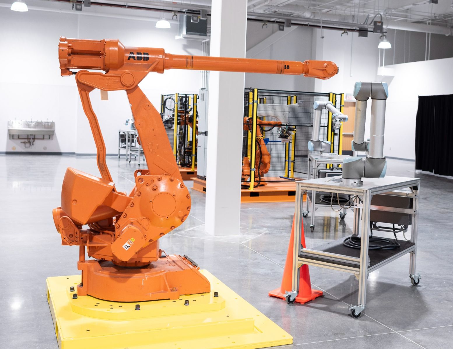 The robotics training area is designed with maximum flexibility; robot cells are on self-contained pallets designed to be moved easily and plugged into an overhead electrical outlet.  (Photo/Fred Rollison)