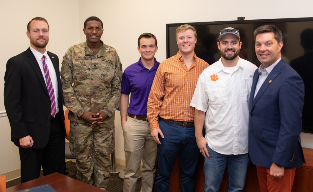 Brennan Beck (left), director of military and veteran engagement at Clemson, with Newport News Shipbuilding scholarship recipients Daquan Doctor, who serves in the Army National Guard; Damion Anderson, who served in the Marine Corps; Giff Finley, who served in the Coast Guard; and Stewart Fuller, who is on active duty with the Navy. At right is alumnus Matt Needy, who is the company's vice president of operations.