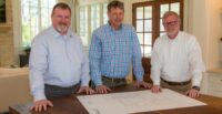 Keith Poole, Matt Ruth and Will Huss look at house plans for a custom home. Their company’s new division will focus on high-end single-family homes. (Photo/Trehel Tailored Homes)